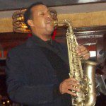 A man playing the saxophone in front of a crowd.