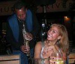 A man and woman playing the saxophone at an event.