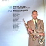 A man in suit and tie holding a saxophone.